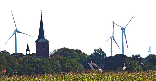 Der Kirchturm von Esens, im Hintergrund der vier Kilometer entfernte Windpark Stedesdorf, Foto (C): Manfred Knake